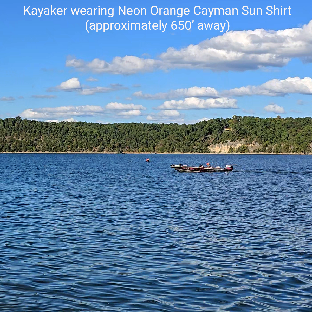 Kayaker in distance wearing Paragon Cayman Hi-Visibility Sun Shirt Neon Orange with boat traffic